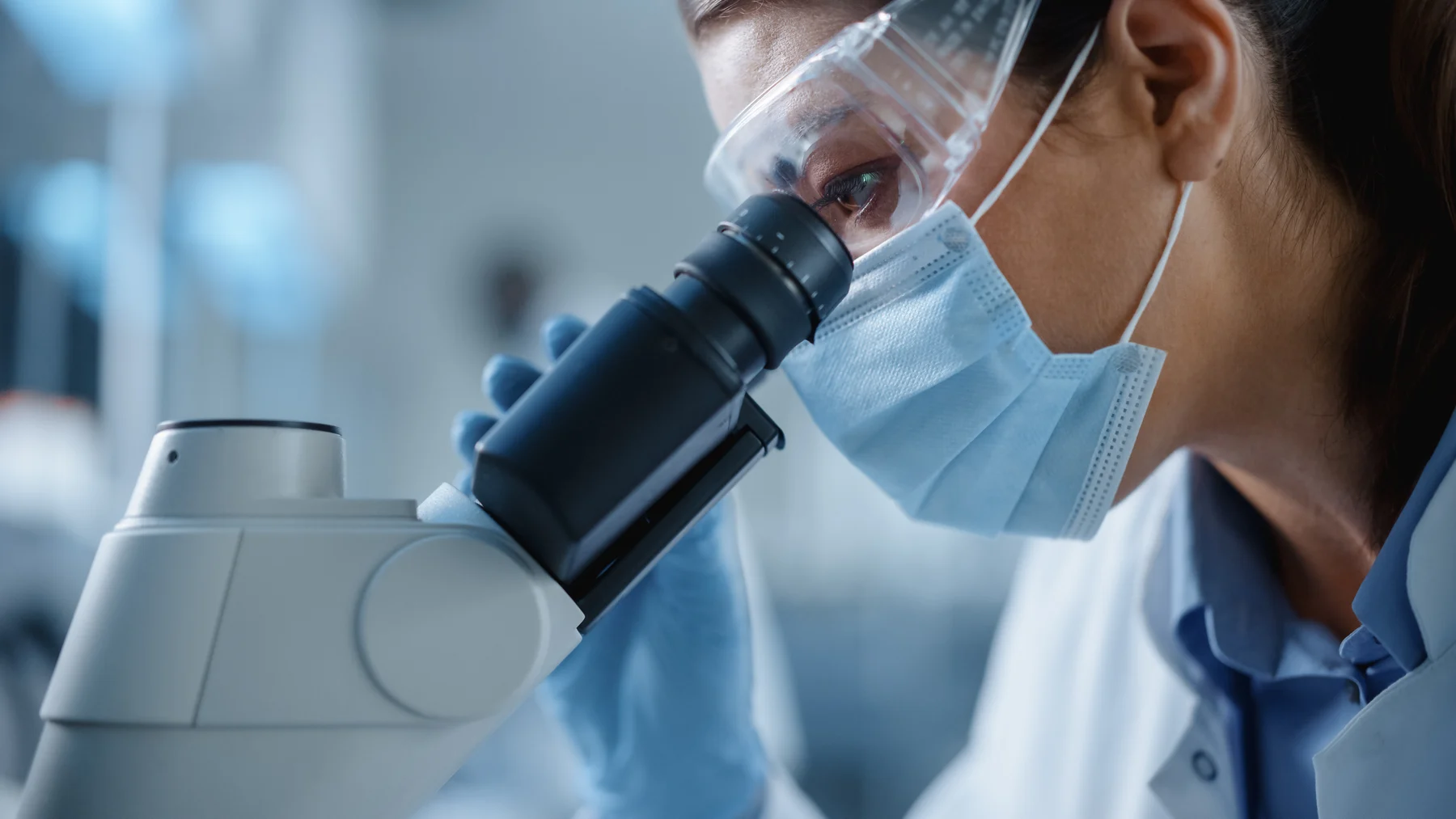A research scientist examining samples through a microscope